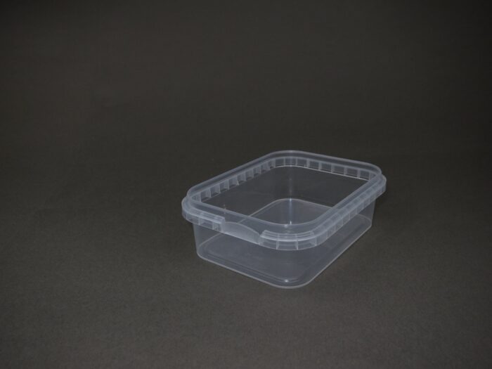 A plastic container with a lid on the ground.