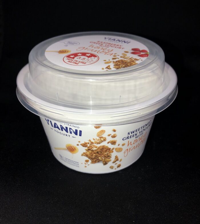 A container of yogurt with granola on top.