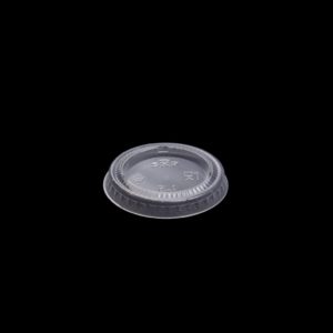 A plastic lid for a container on a black background.